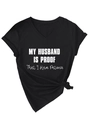 Close-up of black V-neck T-shirt with 'MY HUSBAND IS PROOF' text and knotted hem detail - Black