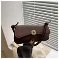 Detail of a brown leather shoulder bag featuring a gold circular buckle and knotted strap - Brown