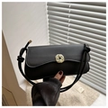 Detail of a matte black underarm bag featuring a golden knot clasp and thick rope strap - Black