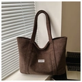 Detail of coffee brown corduroy tote bag showing ribbed texture and fashion label - Coffee