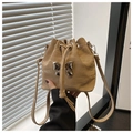 Détail du sac seau beige avec un grand nœud métallique argenté et fermeture à cordon - Kaki