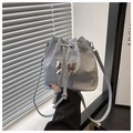Close-up of sky blue drawstring bucket bag featuring a silver metal bow and wrinkled texture - Blue