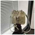 Detail of light green drawstring bucket bag with silver bow ornament and soft texture - Green