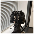 Détail du sac seau noir avec nœud en métal argenté et texture en cuir plissé élégant - Noir