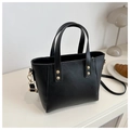Détail d'un sac cabas noir en simili cuir avec boucles dorées et bandoulière amovible - Noir