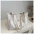 Détails du sac cabas crème avec ornements papillons et texture plissée élégante - Blanc