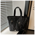 Details der schwarzen Falten-Tote-Bag mit silbernen Schmetterlingen und Magnetverschluss - Schwarz