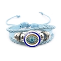Primer plano de pulsera de cuero trenzado azul claro con ojo turco y cuentas plateadas - Estilo Azul 8
