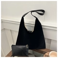 Detail of minimalist black velvet tote bag with matching leather pouch on wooden table - Black