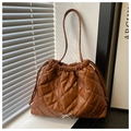 Close-up of brown quilted drawstring tote bag with silver bow and diamond stitching - Brown