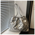 Detail einer silbernen Stepptasche mit Kordelzug und feiner Metallschleife am Verschluss - Silber