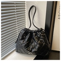 Detail der schwarzen Stepptasche mit silberner Schleife und Kordelzug am Fensterbrett - Schwarz