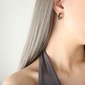 Boucles d'oreilles créoles argentées en C avec zircons verts sur modèle femme - Zircon Vert Acier