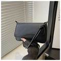 Detail of matte black leather bag with wave flap and gold hardware accents - Black