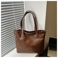 Detail van een grote bruine tote bag met geometrisch patchwork design op een bureau - Bruin