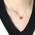 Collar de oro rosa con colgante doble felicidad usado por una modelo sobre tejido negro - 40+5cm / Oro rosa