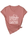 Détail d'un t-shirt à col en V avec texte 'Emotionally Attached' et noeud à l'ourlet - Or Rose (Police Blanche)