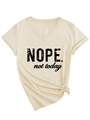 Detail of the V-neck shirt showing the NOPE text and the stylish side knot design - S / Sand (Black Font)