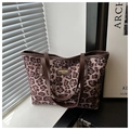 Detalle del bolso tote con estampado de leopardo, asas de cuero marrón y logo dorado - Rosa