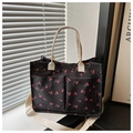 Détail du cabas noir à motif cerises avec sangle blanche et poches frontales - Noir