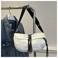 Detailed macro view of Toile de Jouy pattern fabric on a pleated crescent shoulder bag - Blue