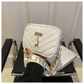 Detail of white quilted crossbody bag with golden deer charm and wide patterned strap - White