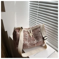 Detail of striped jacquard cylinder bag showing texture, dual zippers, and strap - Orange