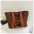 Detail der gesteppten Nylon-Tasche mit braunen Rauten und leuchtend orangen Henkeln - Braun