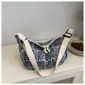 Detailopname van een blauw-witte bloemen canvas tas op een wit kastje met decoratie - Blauw
