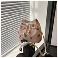 Close-up of strawberry print corduroy bucket bag with drawstring and golden metal bead - Pink Strawberry
