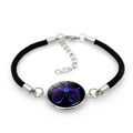 Adjustable black woven bracelet featuring a glowing blue Libra zodiac symbol - Black