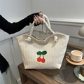 Beigefarbene gewebte Stroh-Tasche mit Kirsch-Stickerei und weißen dicken Seilgriffen - Gebrochenes Weiß