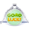 Vue macro du collier trèfle à quatre feuilles argenté avec texte Good Luck et dôme en verre - Combinaison Trèfle et Fer à Cheval (JY009287-6)