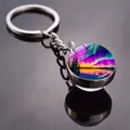 Double-sided aurora glass ball keychain with silver metal ring on a reflective surface - Purple Aurora Lake Style (JY009320-2)