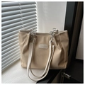 Detalle del bolso tote beige con textura de panal y correas de cadena y cuero - Caqui