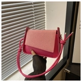 Dettaglio della borsa fucsia con patta intrecciata, tracolla a nodo e dettagli argentati - rosa acceso
