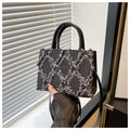 Detail showing distressed grey denim fabric with quilted rhombus pattern and leather handle - Black