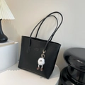 Black embossed faux leather tote bag with long strap and fuzzy charm accessory - Black With Pendant