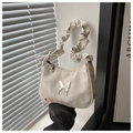 Detail of cream crescent shoulder bag featuring ruched strap and metallic butterfly - White