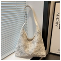 Vue détaillée de la broderie papillon et des franges sur le sac hobo en toile beige - Gris