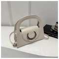 Nahaufnahme cremefarbene Handtasche mit silberner Mond-Schnalle und rundem Griffdetail - Gebrochenes Weiß