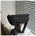 Detail of minimalist black nylon crossbody bag featuring adjustable wide strap and zipper - Black