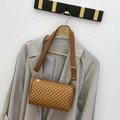 Brown barrel pillow bag with polka dot pattern and wide canvas strap on grey blazer - Tan
