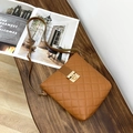 Braune Stepptasche mit Rautenmuster und goldenem Verschluss auf Holzhintergrund - Braun