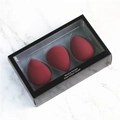 Three burgundy teardrop makeup blending sponges in a black window box on marble - Burgundy