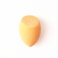 Detail shot of orange teardrop makeup sponge with slanted cut for precise face cleaning - Nude Beveled