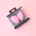 Primer plano de dos esponjas de maquillaje rosas en caja de plástico transparente - lágrima / Rosa
