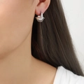 Pendientes geométricos plateados con piedra natural incrustada en una modelo mujer - Color Acero
