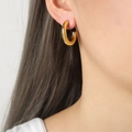 Pendientes de aro en C gruesos bañados en oro de 18k lucidos por una modelo con estilo mini - Dorado