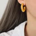 Polished thick gold C-shaped hoop earrings for women on model for a minimalist fashion look - Small Gold Earrings / 2.8cmx3.3cm